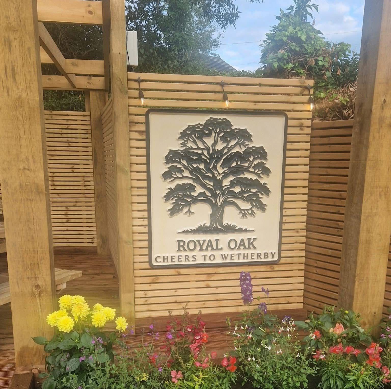 The carved Royal Oak pub sign reading Cheers to Wetherby in the beer garden